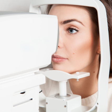 beautiful young brunette lady checks her vision at the clinic. Ophthalmologist. medical, health, ophthalmology concept.